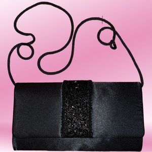Black woman’s clutch with beaded design on front and long shoulder strap
